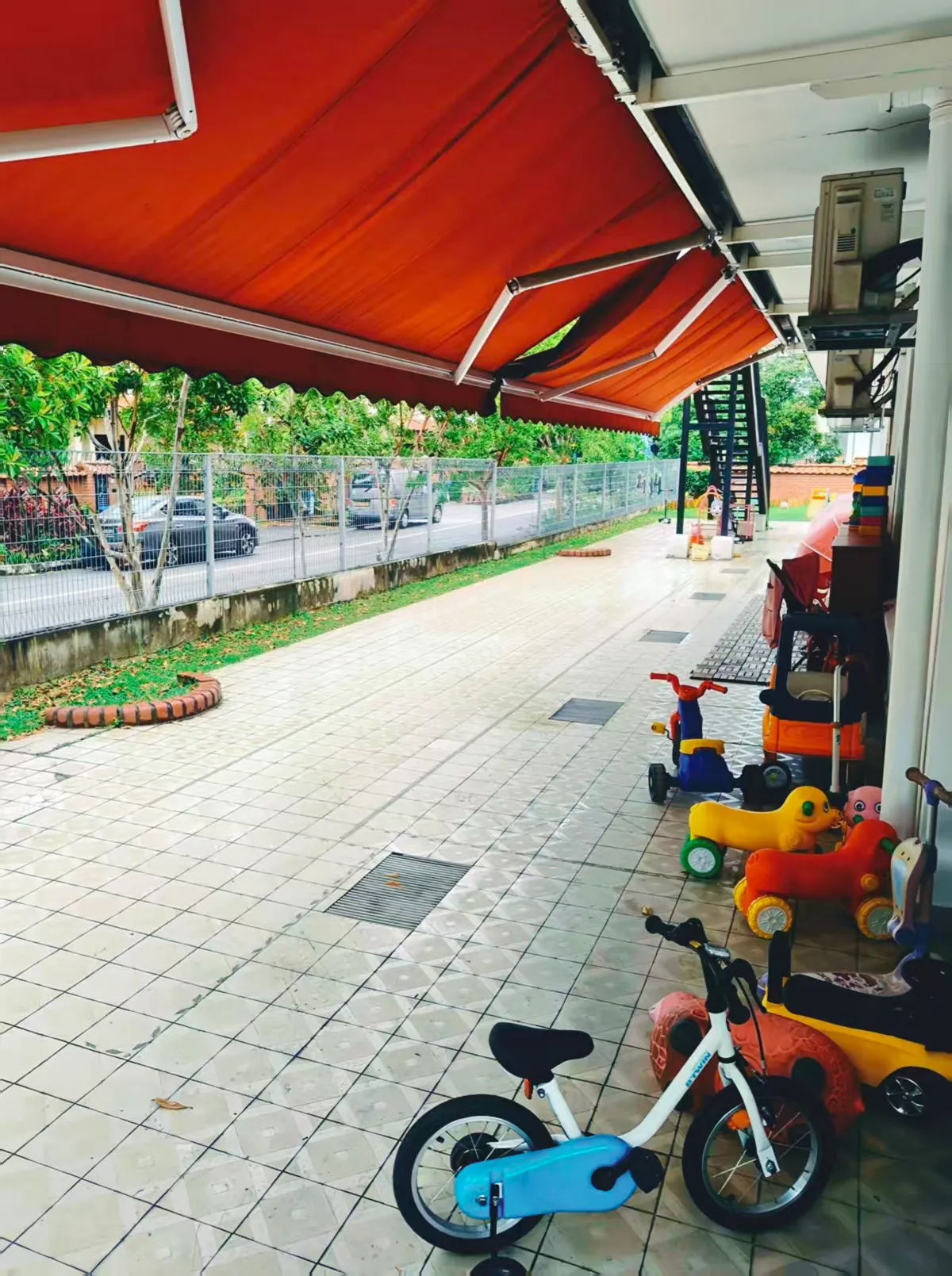 Spacious outdoor play area along the perimeter of MapleBear Jurong West childcare centre campus